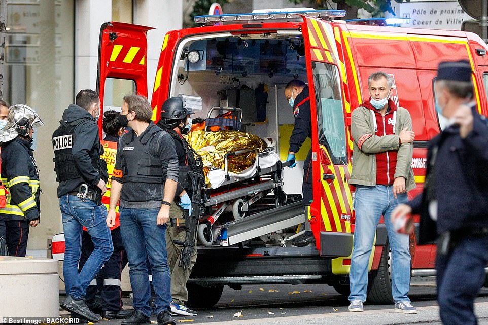 A person who was wounded during the attack on a basilica in Nice is wheeled into the back of an ambulance