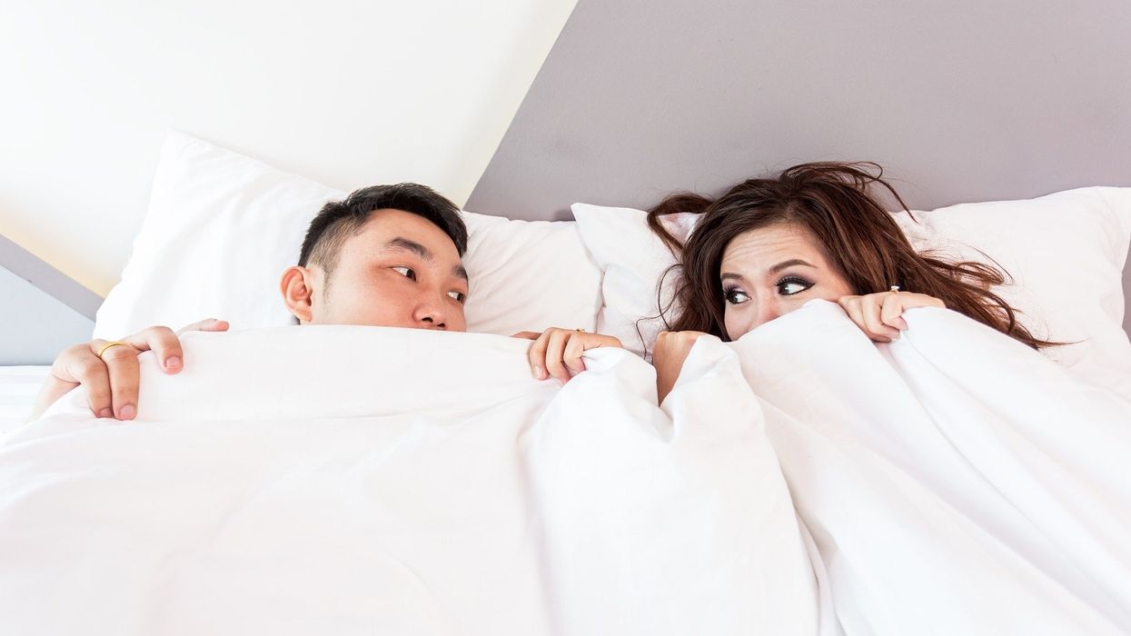 couple under sheets in bed
