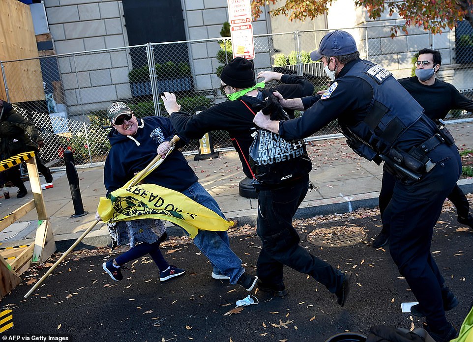 The Trump supporter falls to the ground with the little girl behind him as police grab the counter-protester