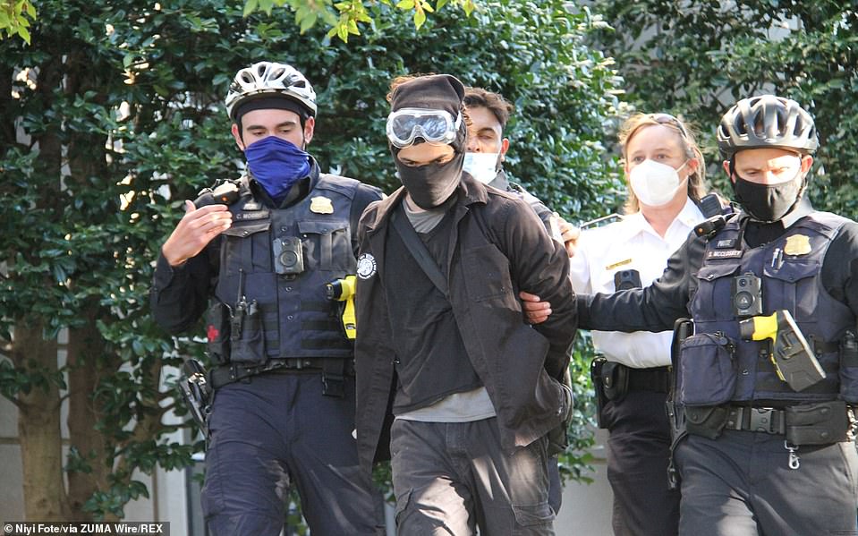 Police detain a counter-protester. DC Metropolitan Police said they made at least 20 arrests, on charges including simple assault, assault on a police officer, and weapons violations