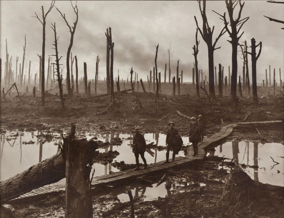 Soldiers of an Australian 4th Division field artillery brigade on a duckboard track passing through Chateau Wood, near Hooge in the Ypres salient, 29 October 1917. The leading soldier is Gunner James Fulton and the second soldier is Lieutenant Anthony Devine. The men belong to a battery of the 10th Field Artillery Brigade. Australian War Memorial collection number E01220.