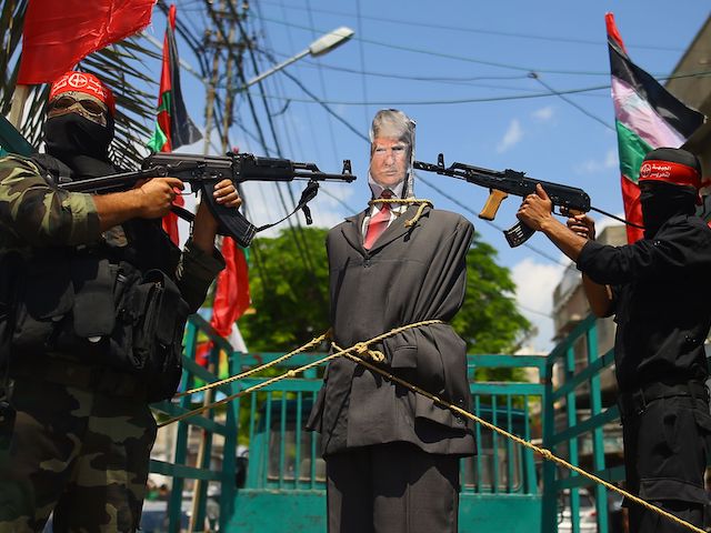 Palestinian militants from the Popular Front for the Liberation of Palestine (PFLP) aim their weapons at an effigy depicting US President Donald Trump as they ride a truck during a protest in Gaza City, on May 23, 2017. (Mohammed Abed/AFP via Getty Images)