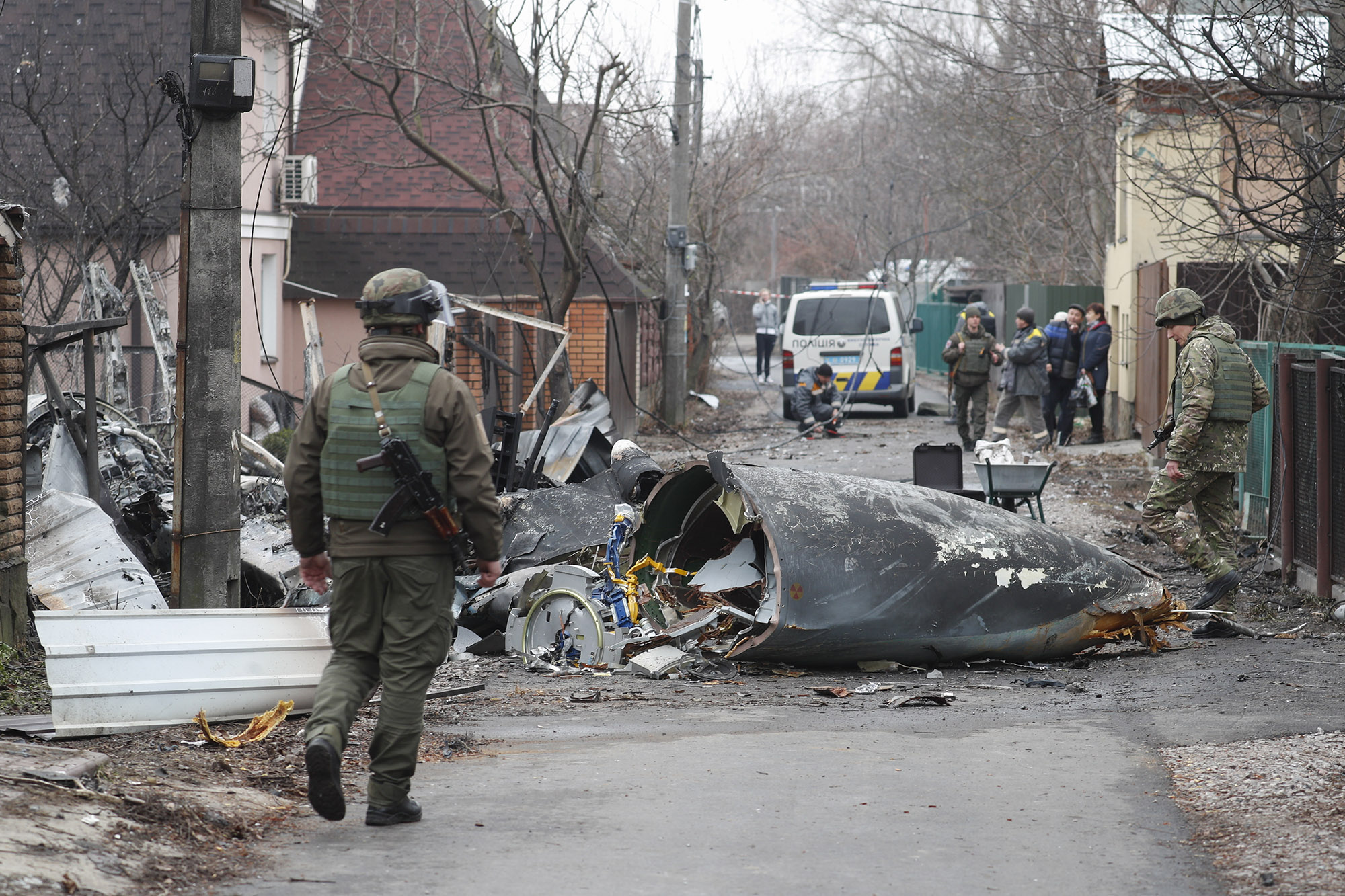 Soldiers look at the debris of a military plane that was shot down overnight in Kiev, Ukraine, 25 February 2022.