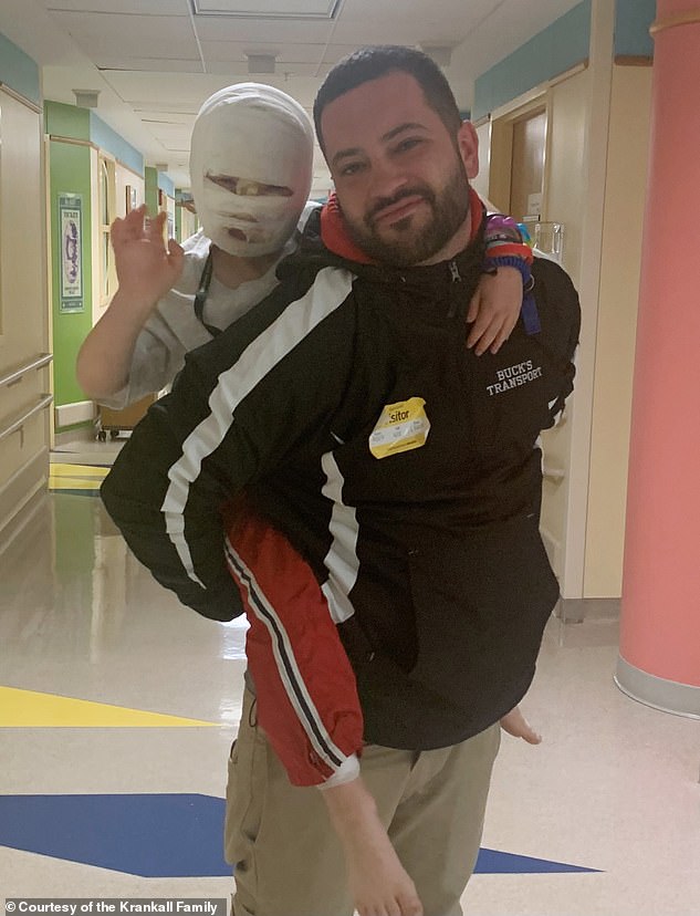 Dominick getting a piggy back from his dad, Aaron Krankall, while waving hello