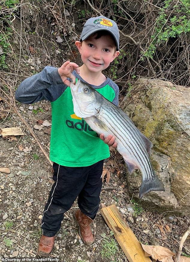 Dominick, who loves being outdoors, is pictures smiling after making a big catch in a photograph taken a few days before he was severely burned