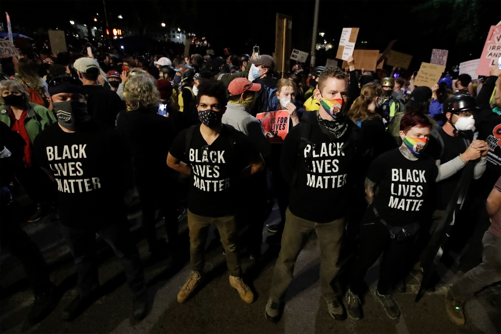 A group of military veterans stand outside the Mark O. Hatfield United States Courthouse during a Black Lives Matter protest Friday, July 24, 2020, in Portland, Ore.
