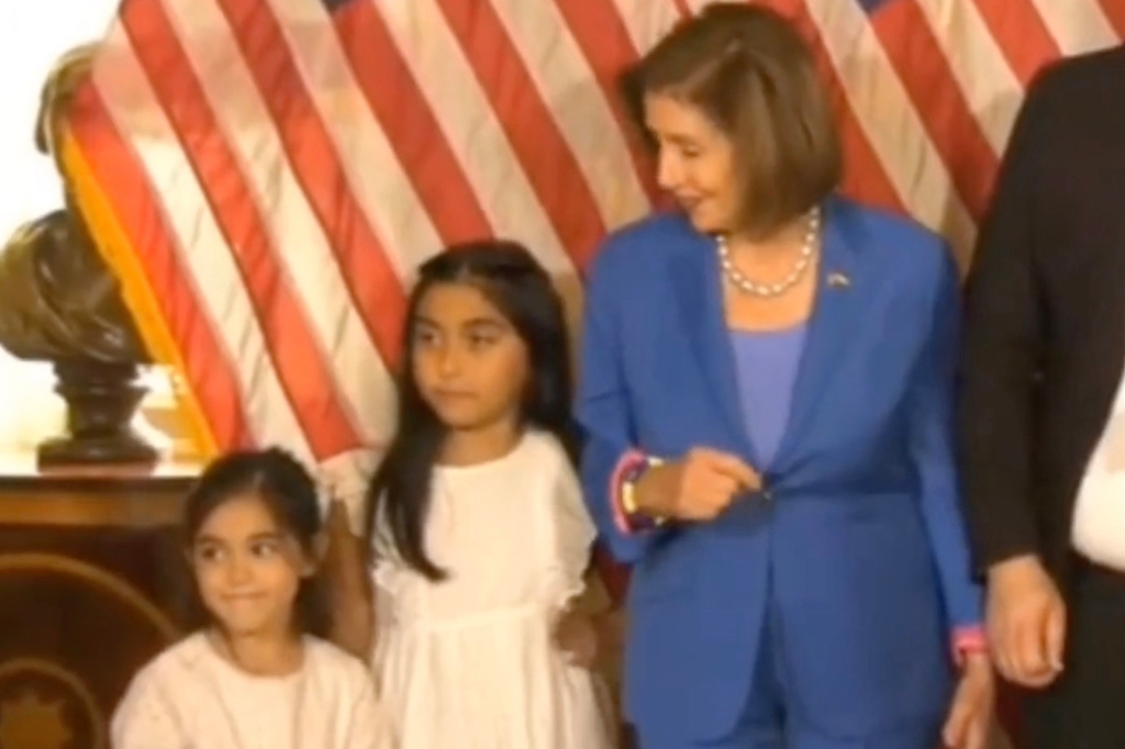 Nancy Pelosi stands next to Mayra Flores' daughters