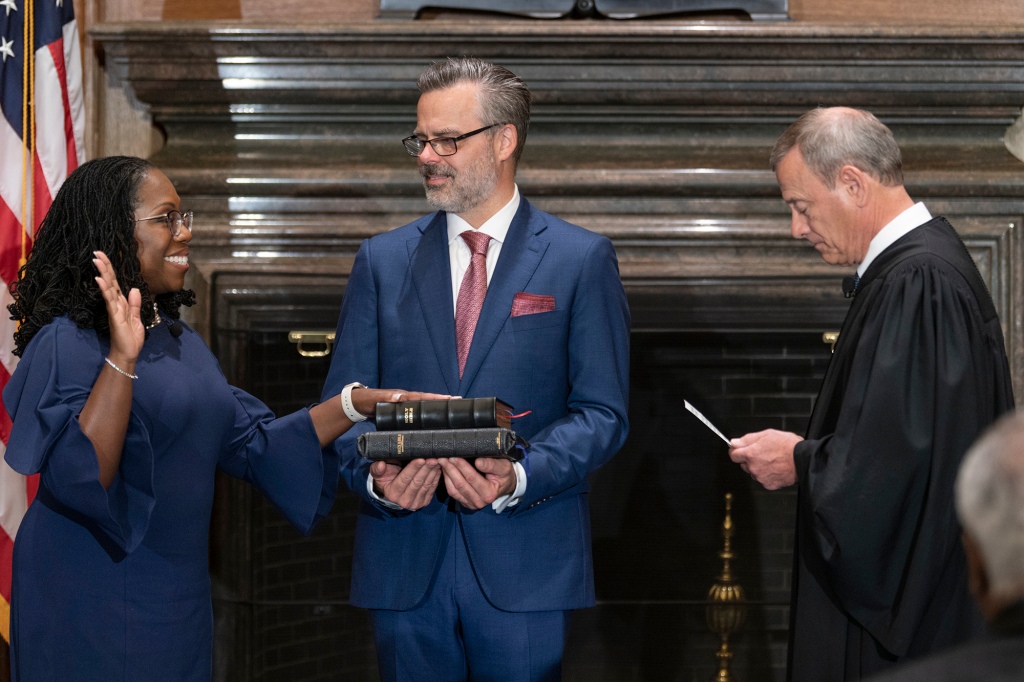 In this image provided by Collection of the Supreme Court of the United States, retired Supreme Court Justice Stephen Breyer administers the Judicial Oath to Ketanji Brown Jackson as her husband Patrick Jackson holds the Bible at the Supreme Court in Washington, Thursday, June 30, 2022.
