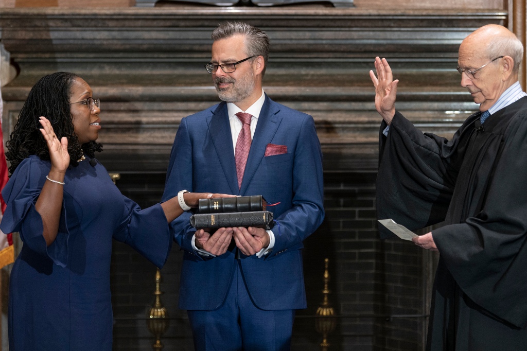 In this image provided by Collection of the Supreme Court of the United States, retired Supreme Court Justice Stephen Breyer administers the Judicial Oath to Ketanji Brown Jackson as her husband Patrick Jackson holds the Bible at the Supreme Court in Washington, Thursday, June 30, 2022.