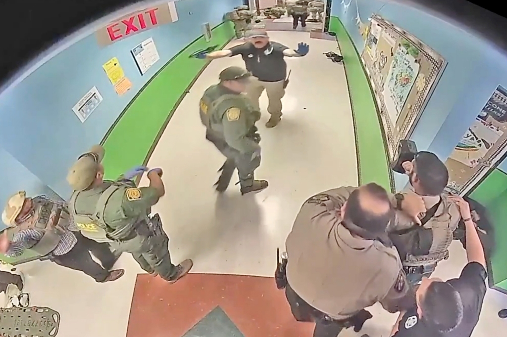 Cops stand in the hallway.