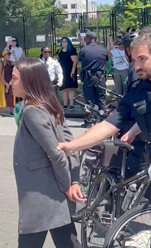 Ocasio-Cortez held her wrists together like they were handcuffed at the protest.