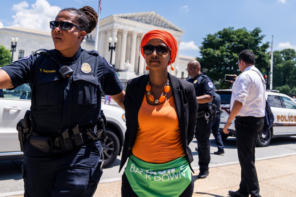 Rep. Ilhan Omar getting escorted away from the protest.