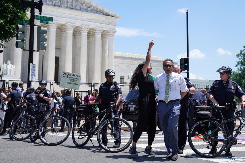 Rep. Rashida Tlaib points her finger up while being arrested by Capitol Police officers during an abortion rights demonstration.