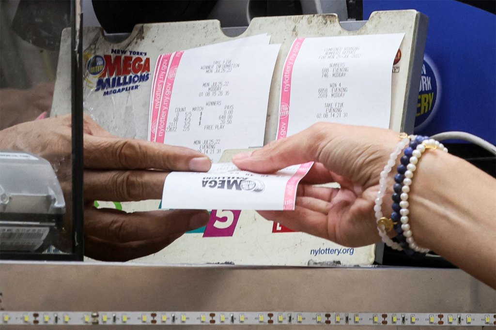 A woman buys a ticket for the Mega Millions lottery drawing at a news stand in New York City on July 26, 2022.  