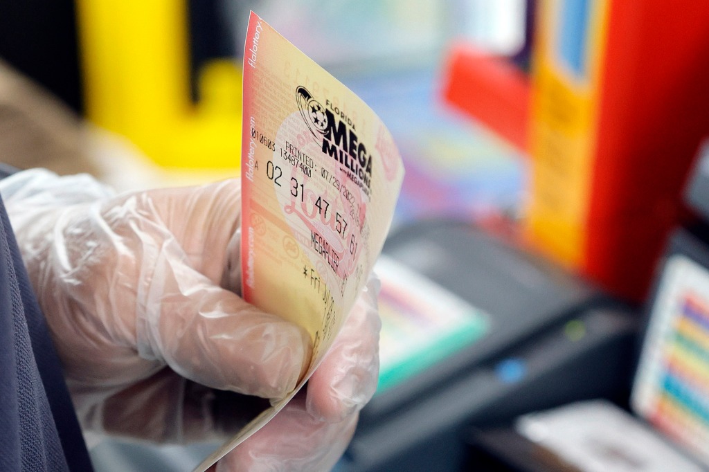 Andres Fernandez sells Mega Millions lottery tickets at a Chevron station in Oakland Park, Fla., on Friday, July 29, 2022.