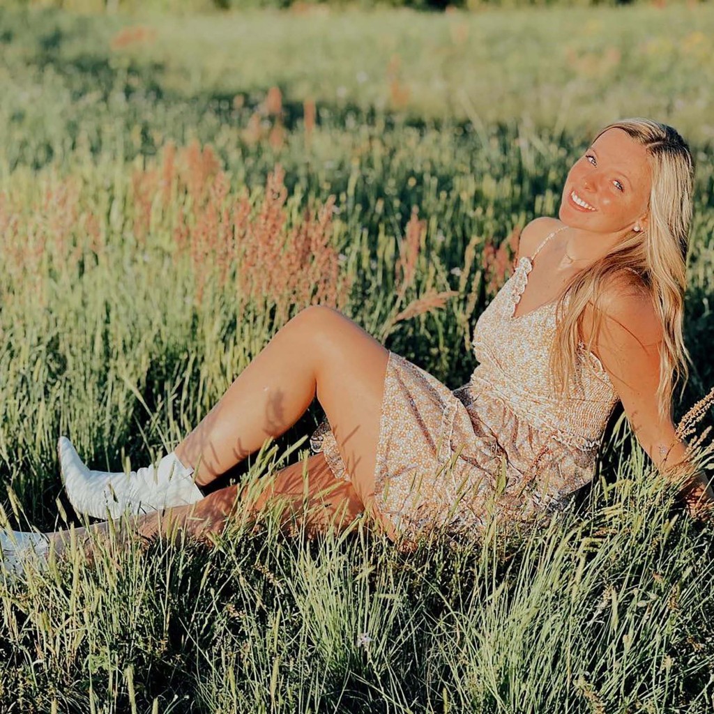 Anna Jones sits in the grass.