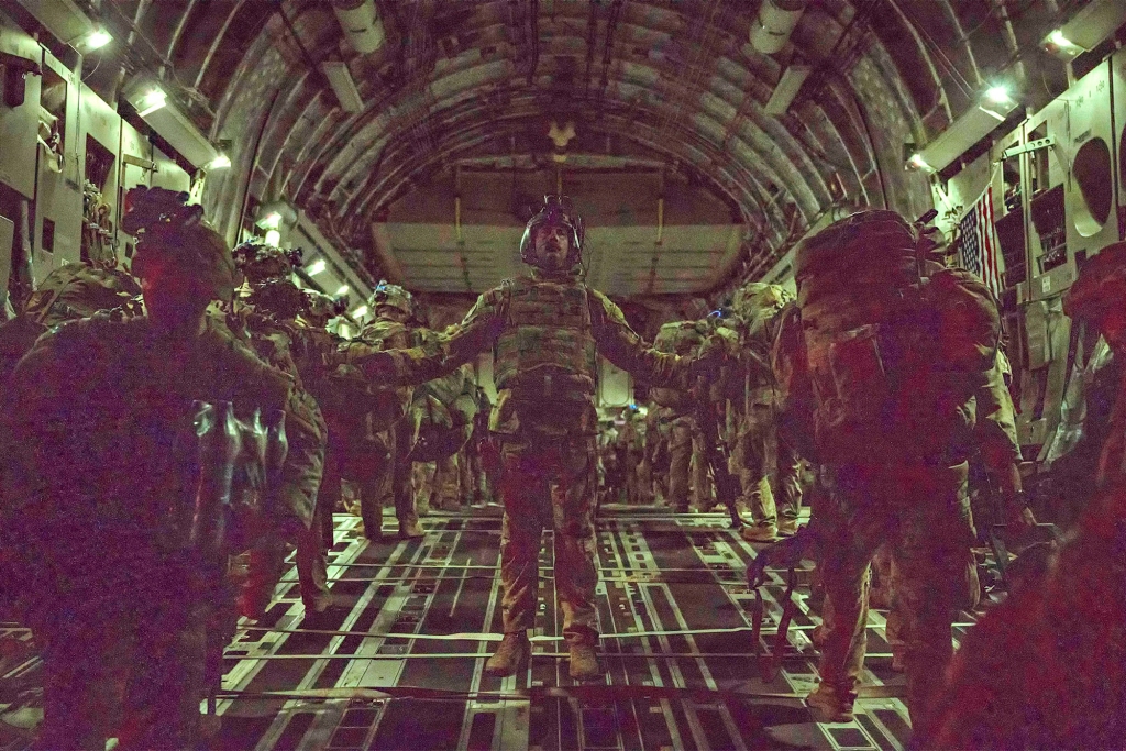 Air Force loadmaster, assigned to the 816th Expeditionary Airlift Squadron, guides Army 82nd Airborne Division paratroopers as they board an Air Force C-17 Globemaster III cargo plane as the last American soldiers prepare to leave Afghanistan at Hamid Karzai International Airport August 30, 2021 in Kabul, Afghanistan.