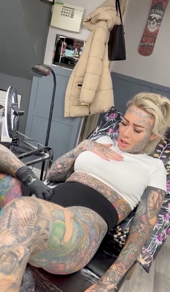 The blonde was seen wincing in pain as she sat on a chair with her legs spread while the artist needled away.