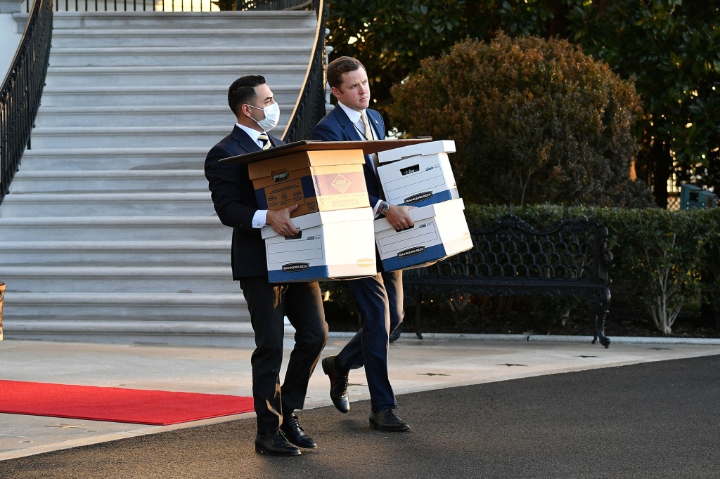 Two men carry cardboard filing boxes outside Mar-a-Lago.