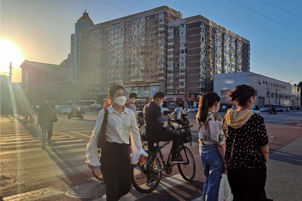 People walk around downtown Beijing