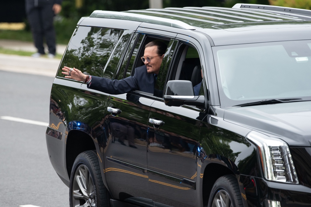 Johnny Depp waves to his fans as he arrives outside court during the Johnny Depp and Amber Heard civil trial at Fairfax County Circuit Court.