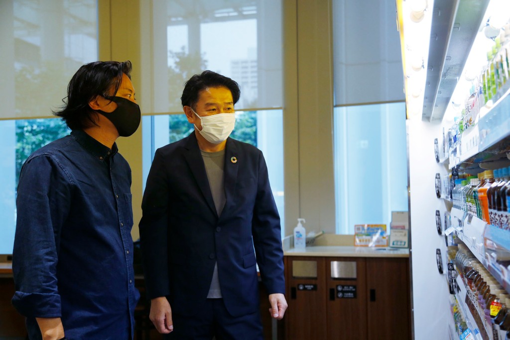 Telexistence CEO Jin Tomioka, left, and FamilyMart Executive Officer Tomohiro Kano look at shelves of a FamilyMart convenience store in Tokyo.