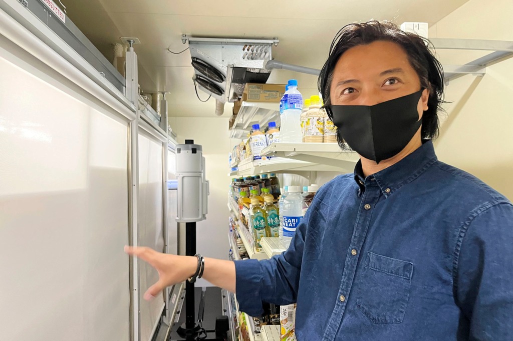 Telexistence CEO Jin Tomioka stands before his company&rsquo;s robot, TX SCARA.