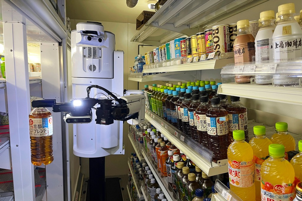 TX SCARA robot works, stocking drinks in the refrigerated section of a FamilyMart convenience store in Tokyo.