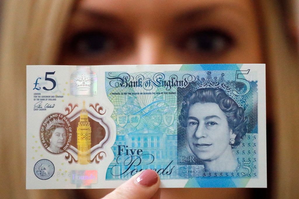 FILE - In this Tuesday, Sept. 6, 2016 file photo, a Bank of England employee shows the new five pound note at the Bank of England Museum in London. The Bank of England has rejected calls to scrap new banknotes that contain traces of animal fat. The bank said Thursday, Aug. 10, 2017, it will continue to issue polymer notes that contain tallow, a rendered form of animal fat.