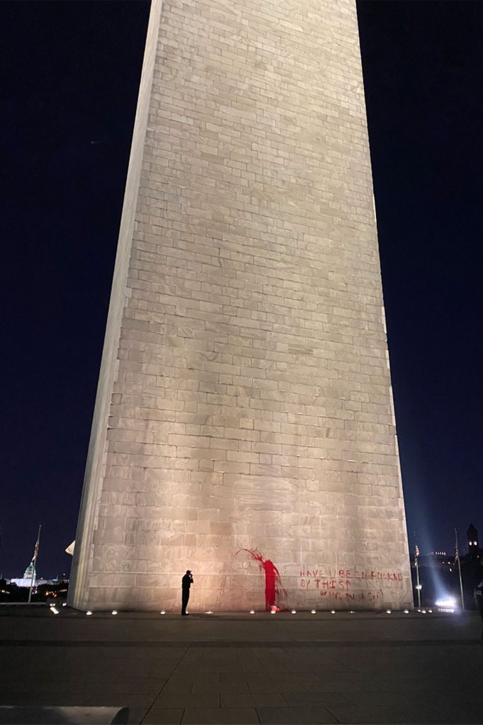 A person stands a the base of Washington Monument. The words 